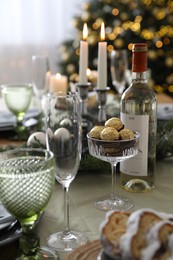 Photo of Christmas table setting with festive decor and glassware indoors