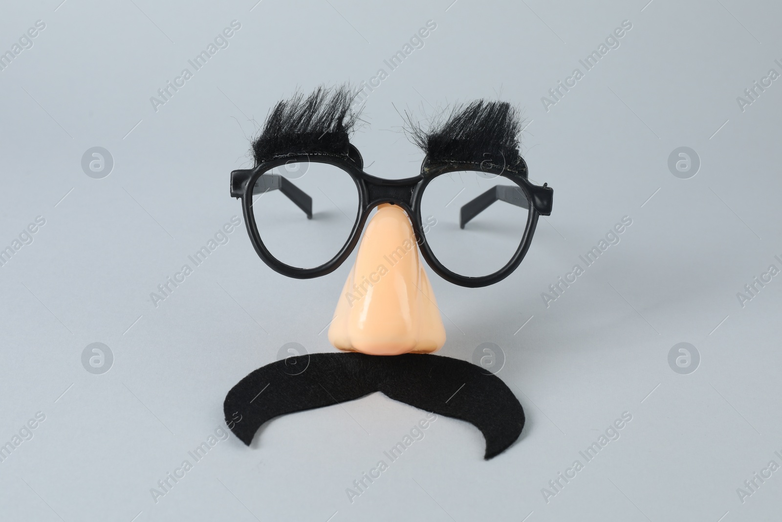 Photo of Funny mask with fake mustache, nose and glasses on grey background