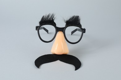 Funny mask with fake mustache, nose and glasses on grey background