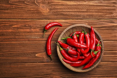 Photo of Flat lay composition with fresh chili peppers and space for text on wooden background