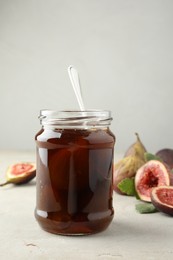Photo of Jar of tasty sweet fig jam on light table