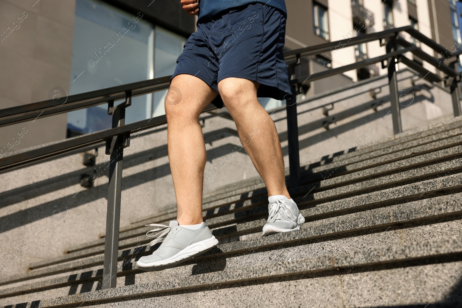 Photo of Man running down stairs outdoors on sunny day, closeup. Space for text