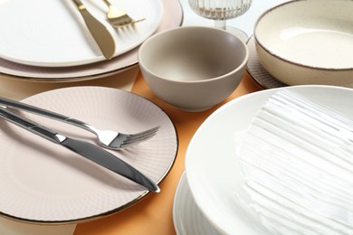 Clean plates, bowls, glass and cutlery on table