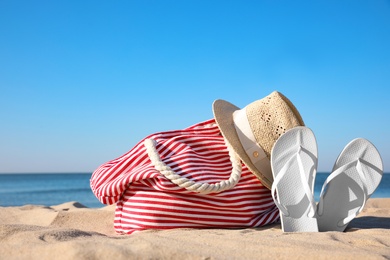 Set with stylish beach accessories on sand near sea