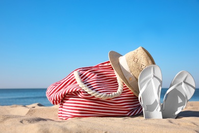 Photo of Set with stylish beach accessories on sand near sea