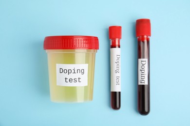 Photo of Jar and test tubes with samples on light blue background, flat lay. Doping control