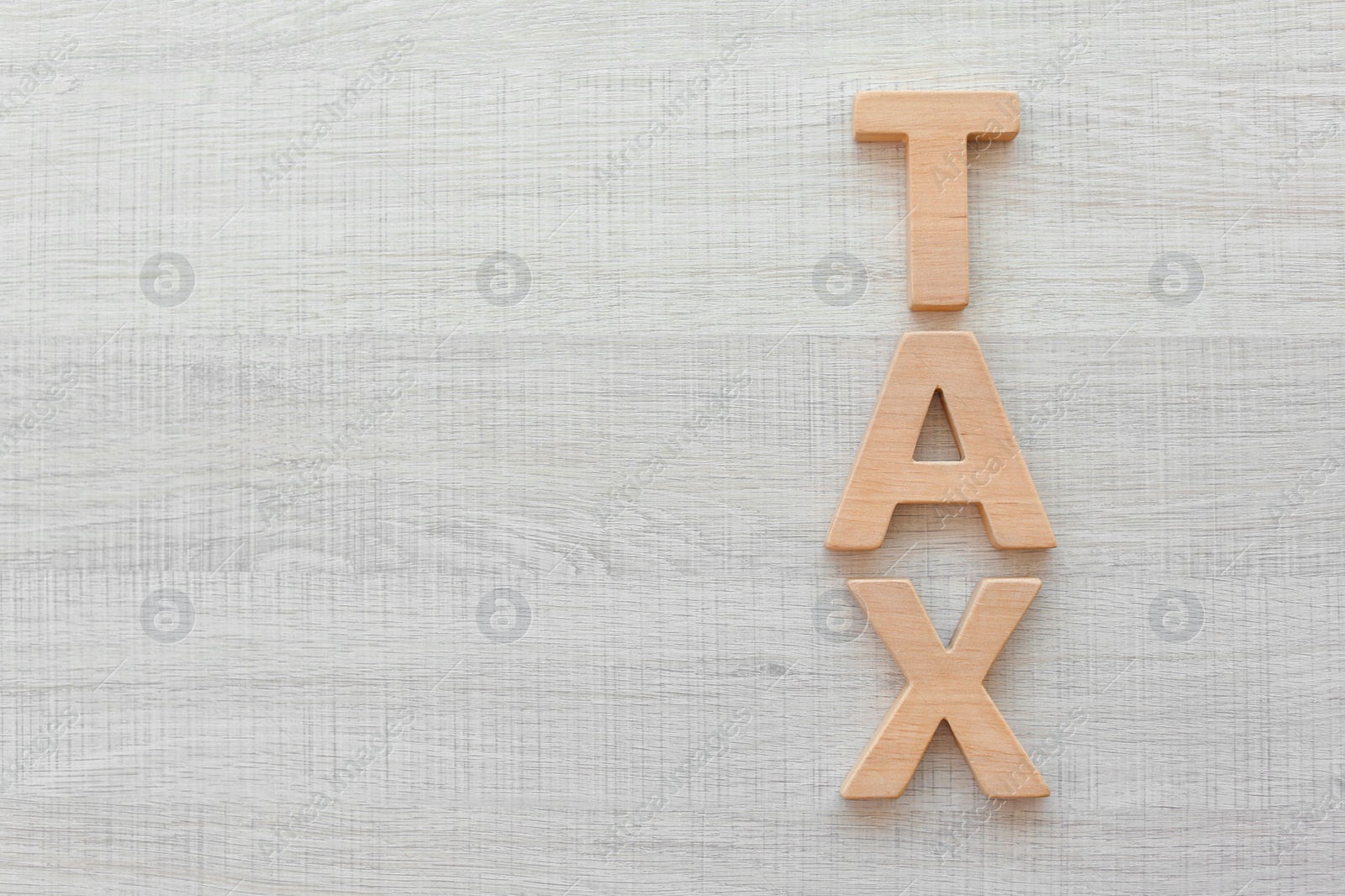 Photo of Word TAX on wooden background, top view