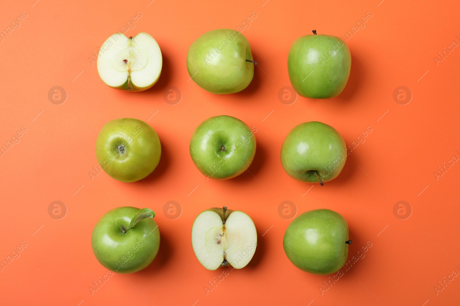 Photo of Tasty green apples on orange background, flat lay