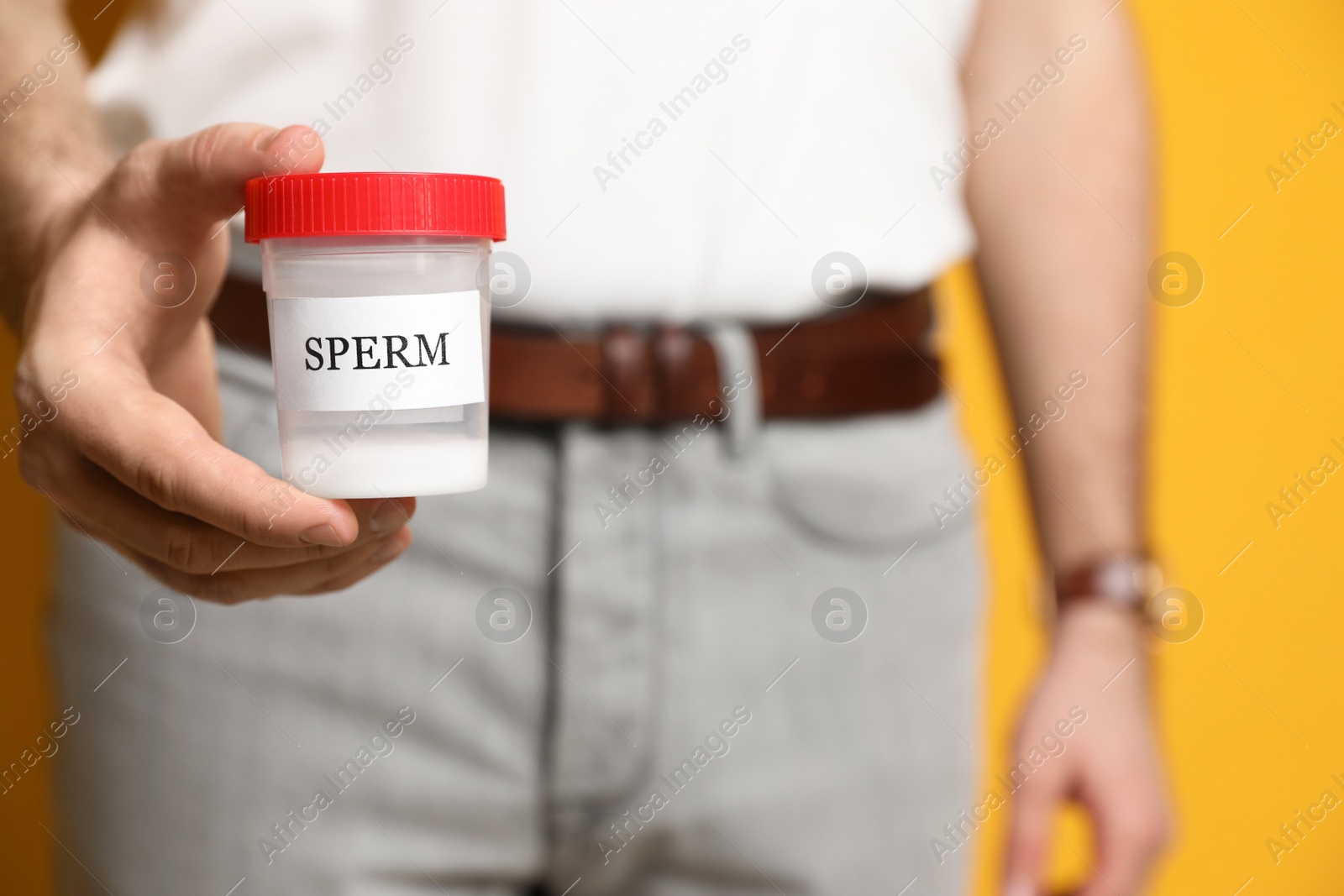 Photo of Donor holding container with sperm, closeup view