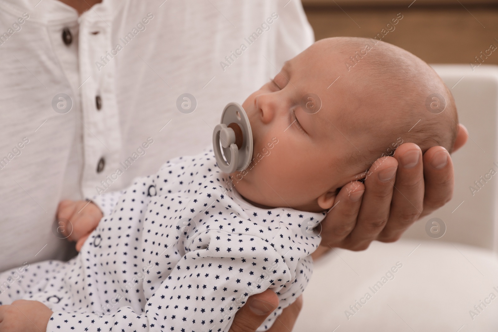 Photo of Father with his cute sleeping baby at home, closeup