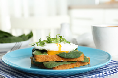 Photo of Delicious poached egg sandwich served on blue plate