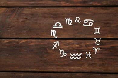 Photo of Zodiac signs on wooden background, flat lay. Space for text