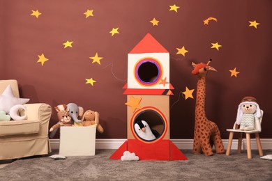 Photo of Child's room interior with cardboard rocket and toys