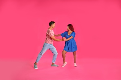 Photo of Beautiful lovely couple dancing on pink background