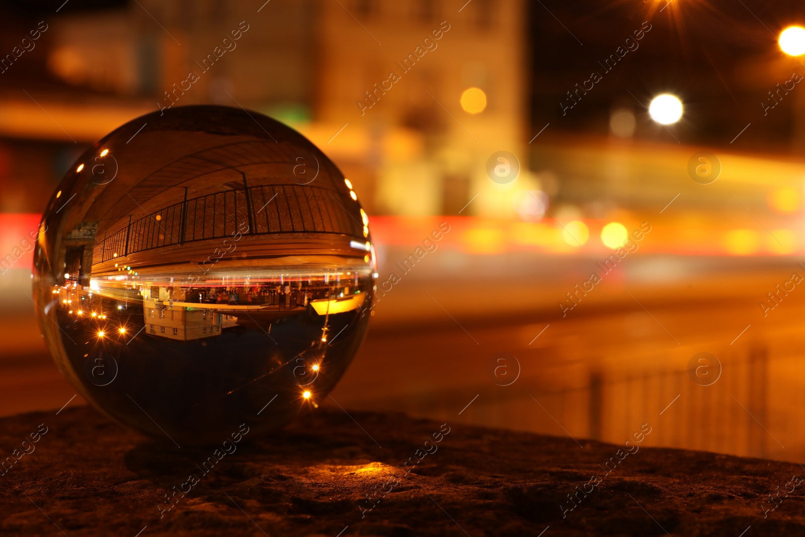 Photo of Beautiful city street, overturned reflection. Crystal ball at night. Space for text