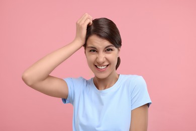 Photo of Portrait of embarrassed young woman on pink background