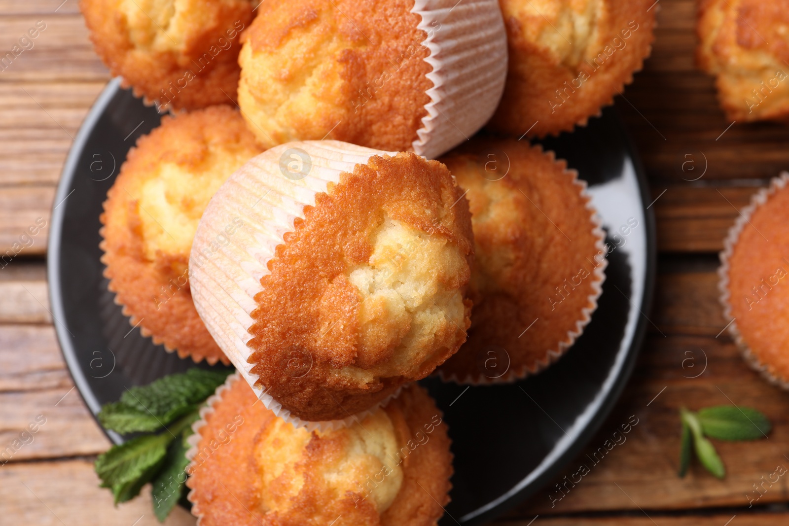 Photo of Delicious sweet muffins on wooden table, flat lay