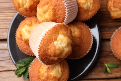 Delicious sweet muffins on wooden table, flat lay