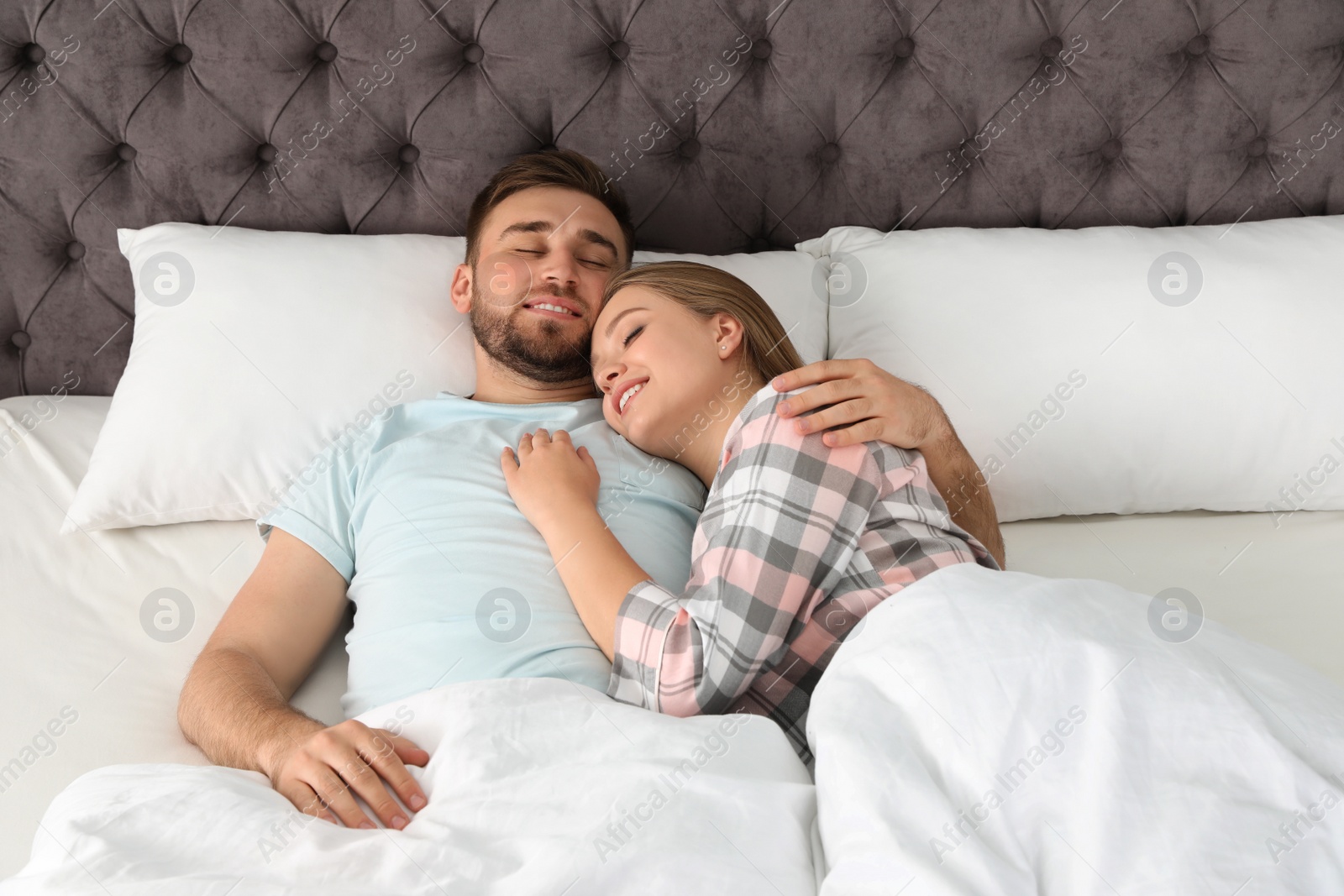 Photo of Young couple sleeping together in bed at home