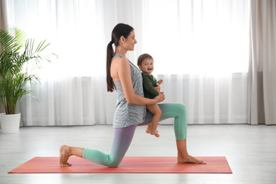 Young woman doing exercise with her son indoors. Home fitness