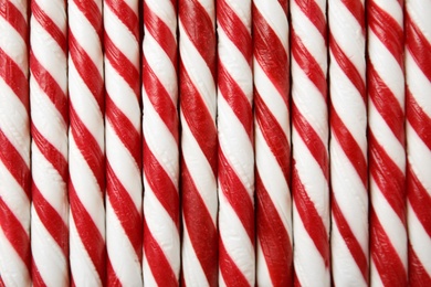 Photo of Sweet candy canes as background, closeup view