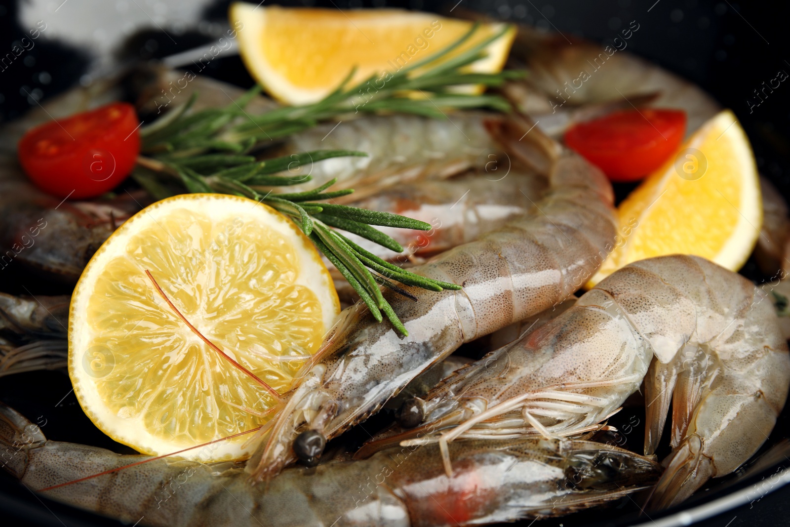 Photo of Fresh raw shrimps with lemon slices, closeup