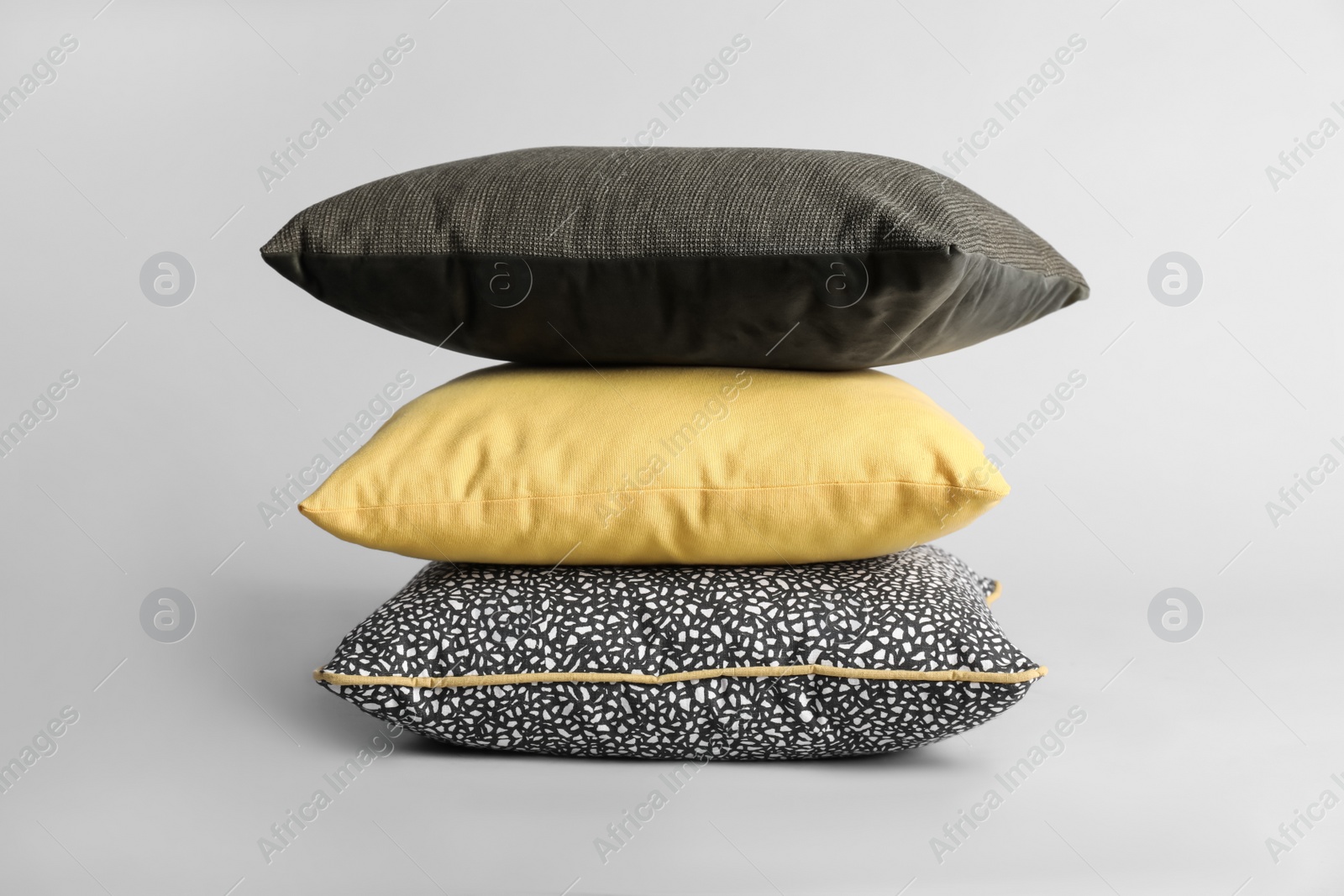 Photo of Stack of stylish soft pillows on grey background