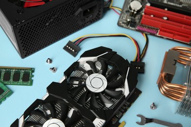 Photo of Graphics card and other computer hardware on light blue background, closeup