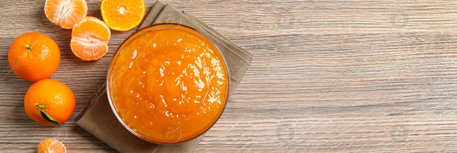 Photo of Flat lay composition with delicious tangerine jam on wooden table. Space for text