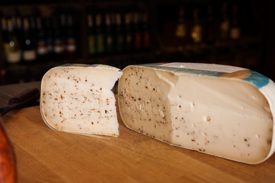 Photo of Cut delicious cheese on table in store