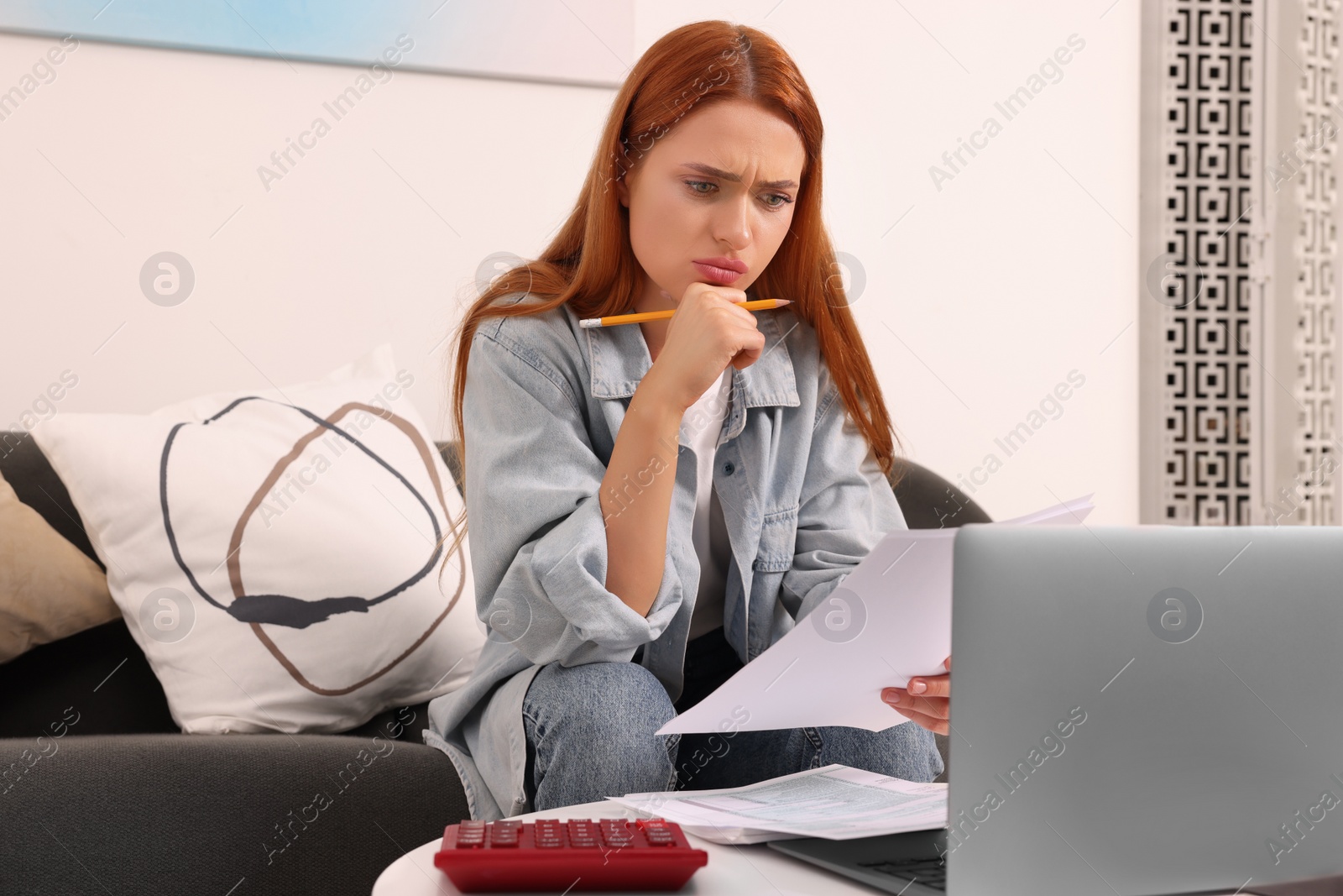 Photo of Woman calculating taxes at table in living room