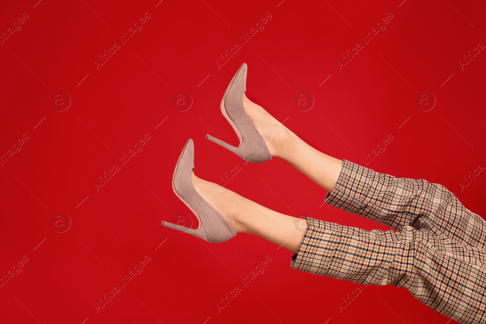 Photo of Woman in elegant shoes on red background