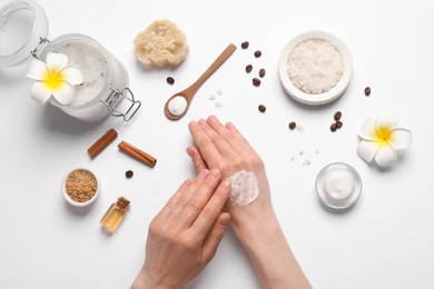 Photo of Woman applying body scrub on hand against white background, top view