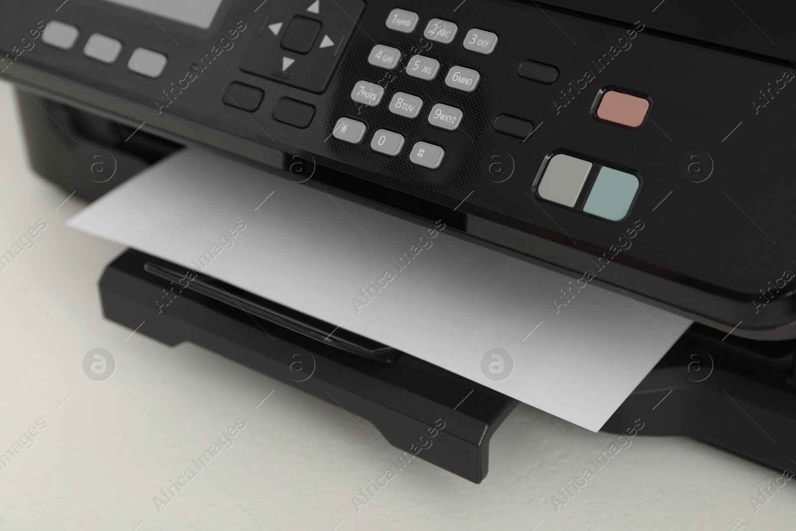 Photo of Modern printer with paper on white table, closeup