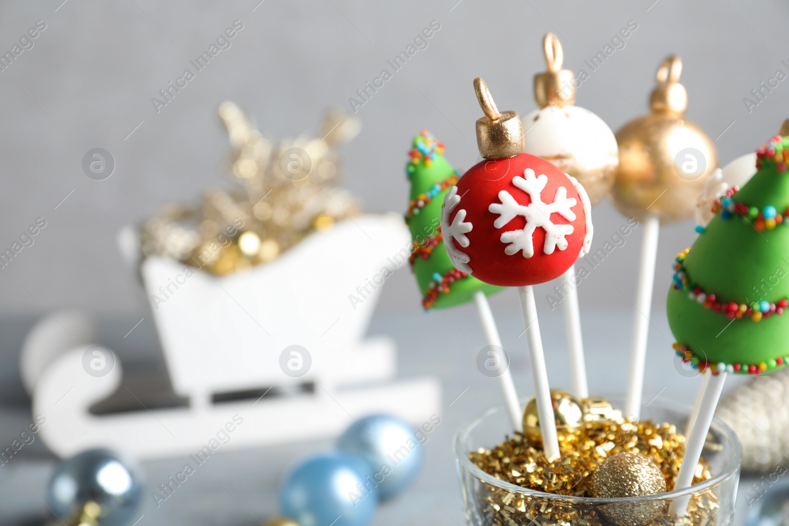 Photo of Delicious Christmas themed cake pops on blurred  background, closeup. Space for text