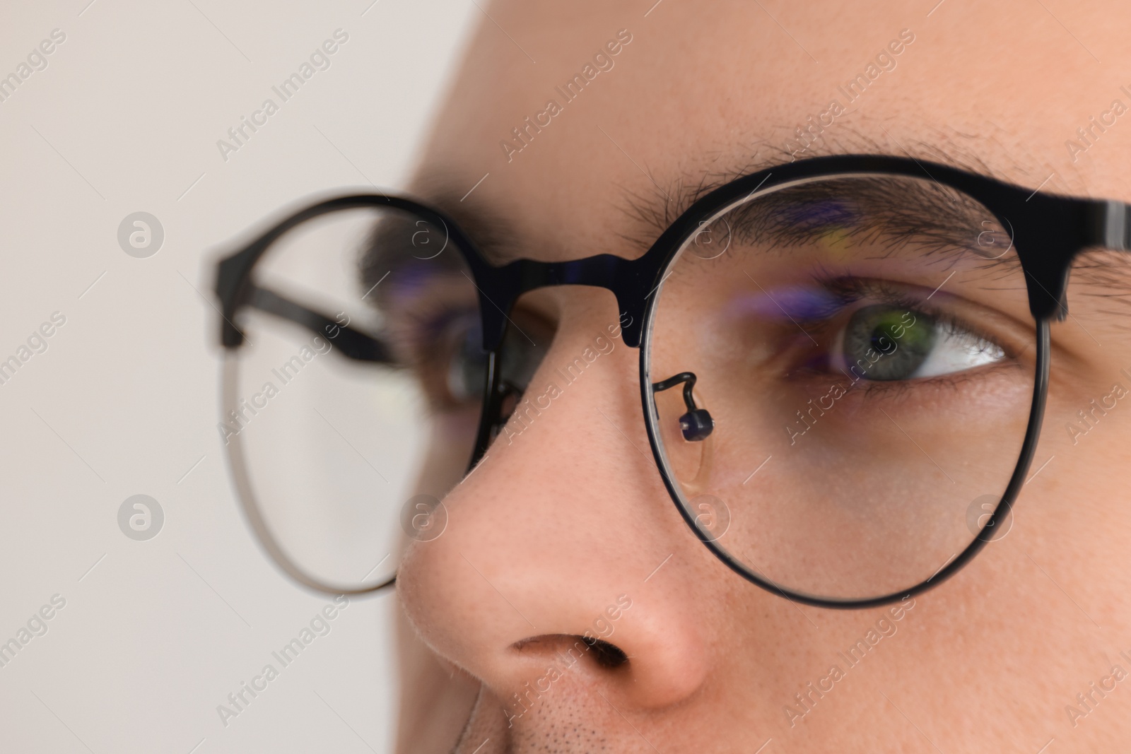 Photo of Man wearing glasses on light background, closeup