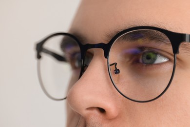 Man wearing glasses on light background, closeup