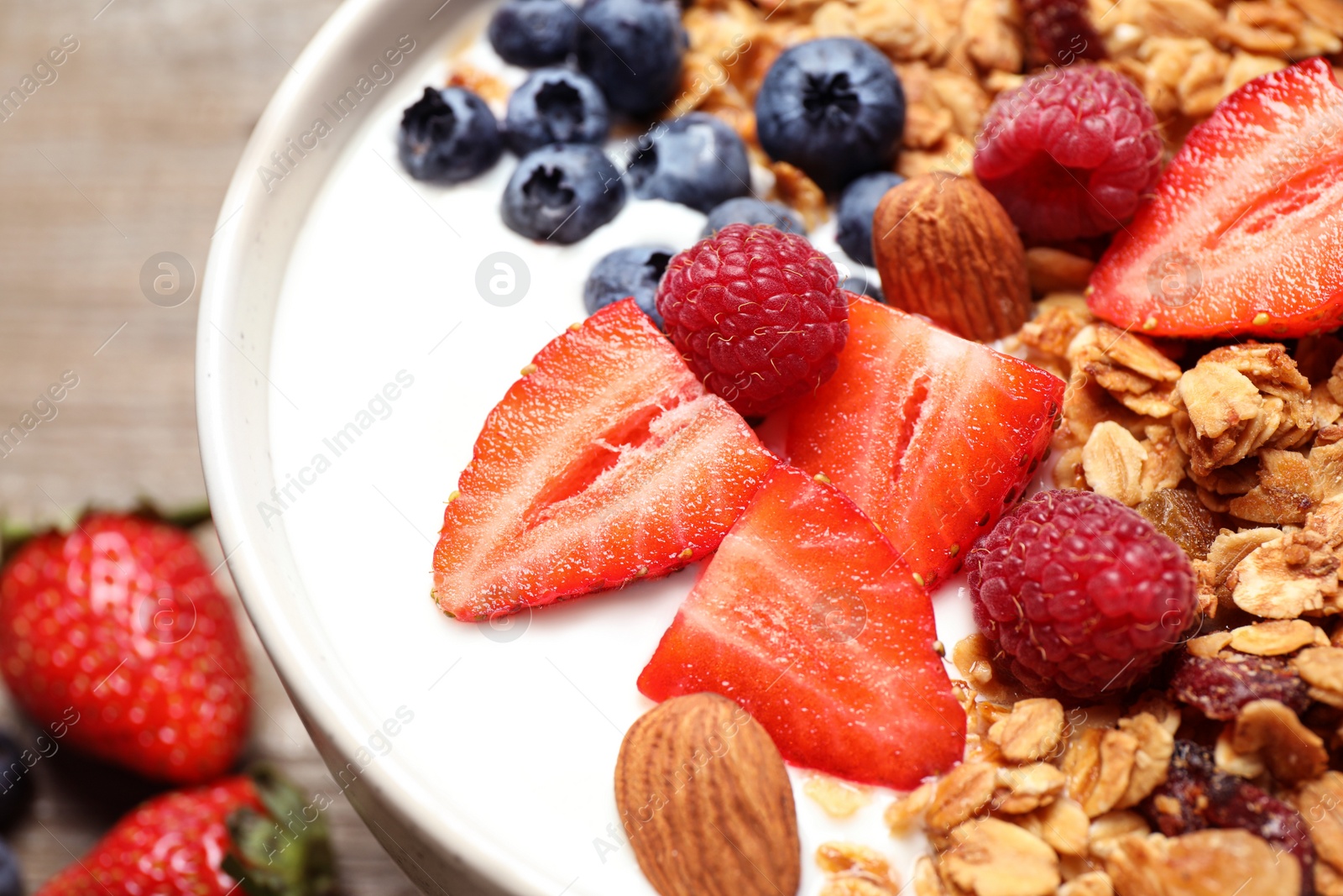 Photo of Tasty homemade granola served on wooden table, closeup. Healthy breakfast
