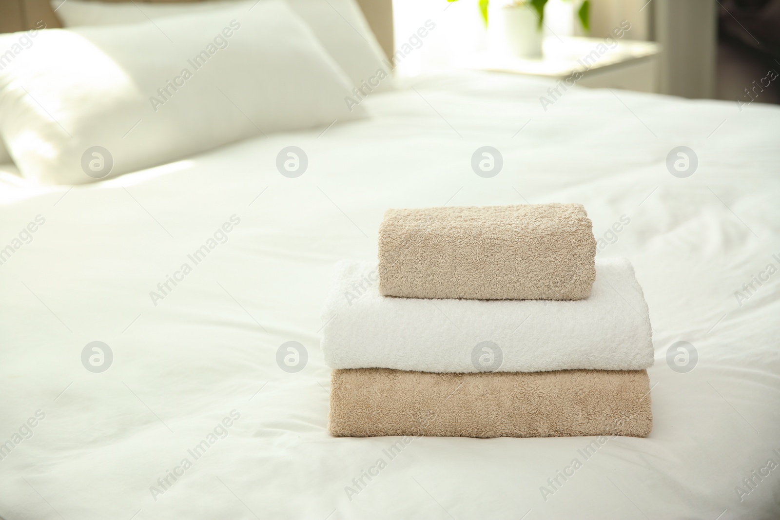 Photo of Soft clean towels on bed at home