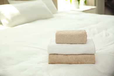 Soft clean towels on bed at home