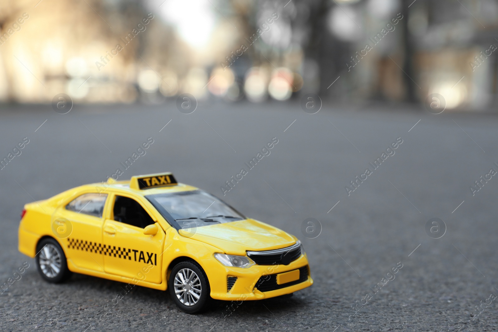 Photo of Yellow taxi car model on city street. Space for text