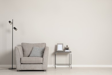 Photo of Stylish armchair near grey wall, space for text. Interior design