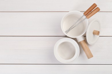 Photo of Fondue set on white wooden table, flat lay. Space for text