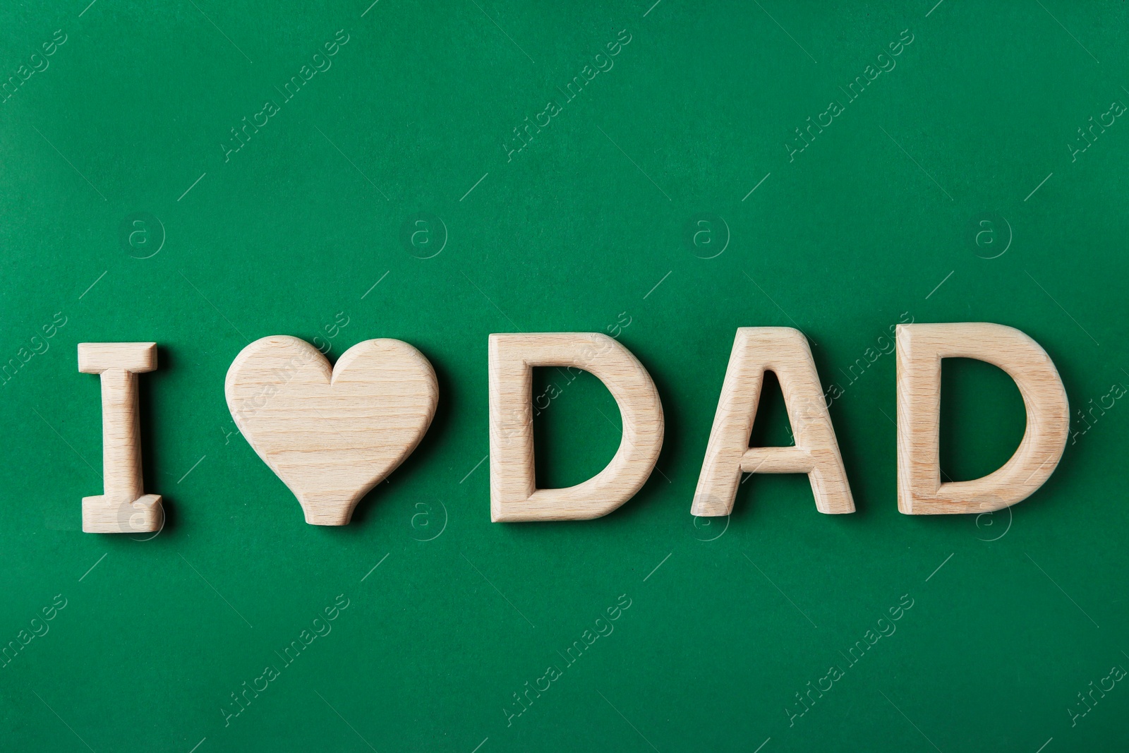 Photo of Phrase I LOVE DAD made of wooden letters on color background, top view