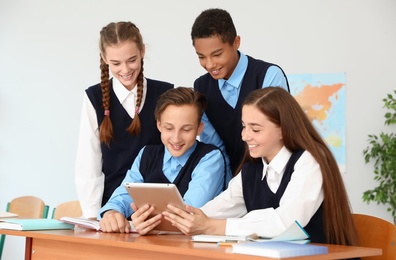 Photo of Teenage students in classroom. Stylish school uniform