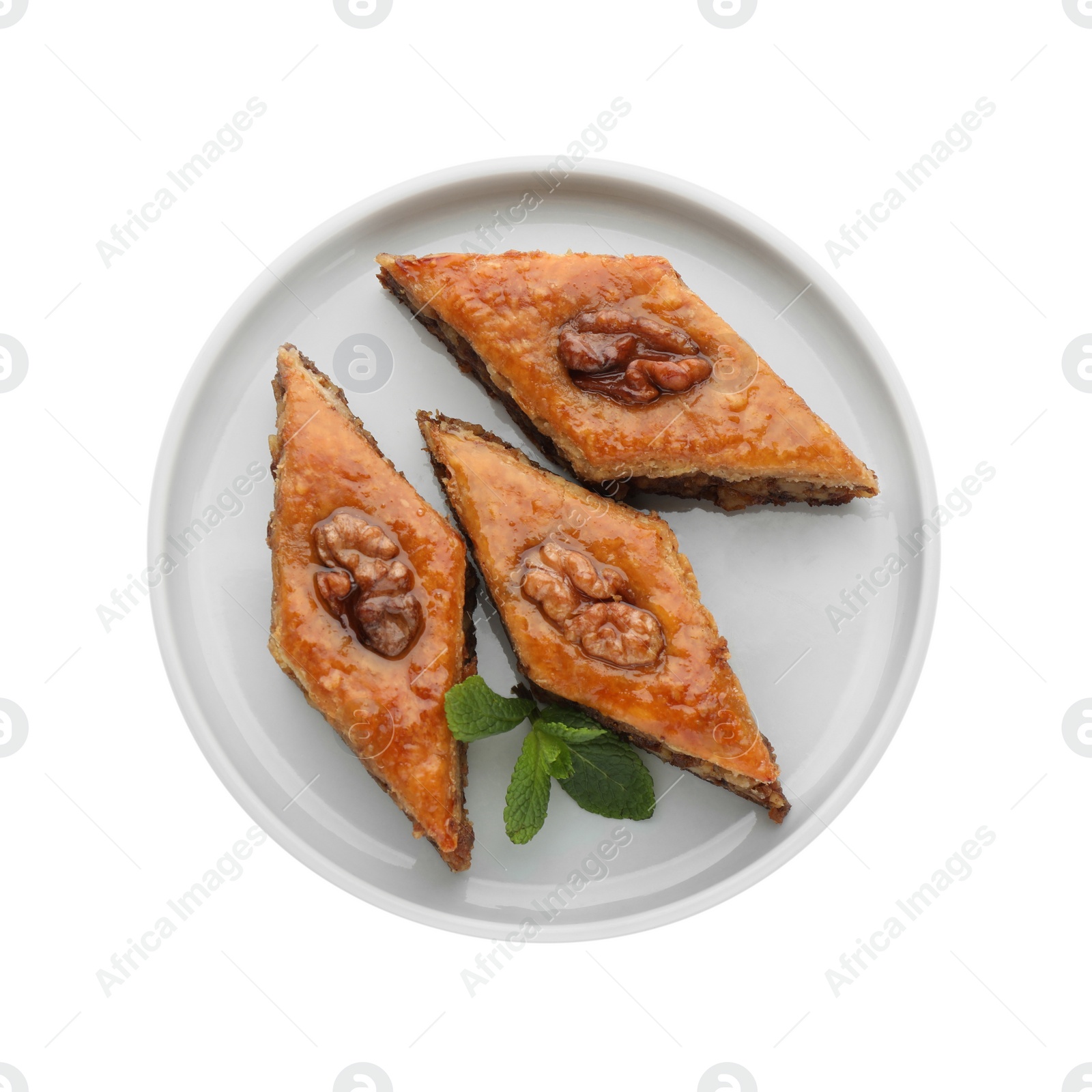 Photo of Plate of delicious honey baklava with walnuts on white background, top view