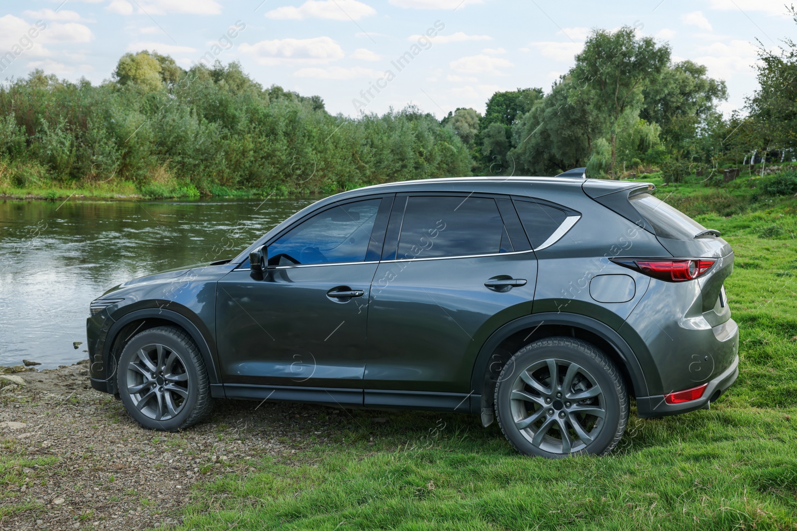 Photo of New black modern car on ground near river