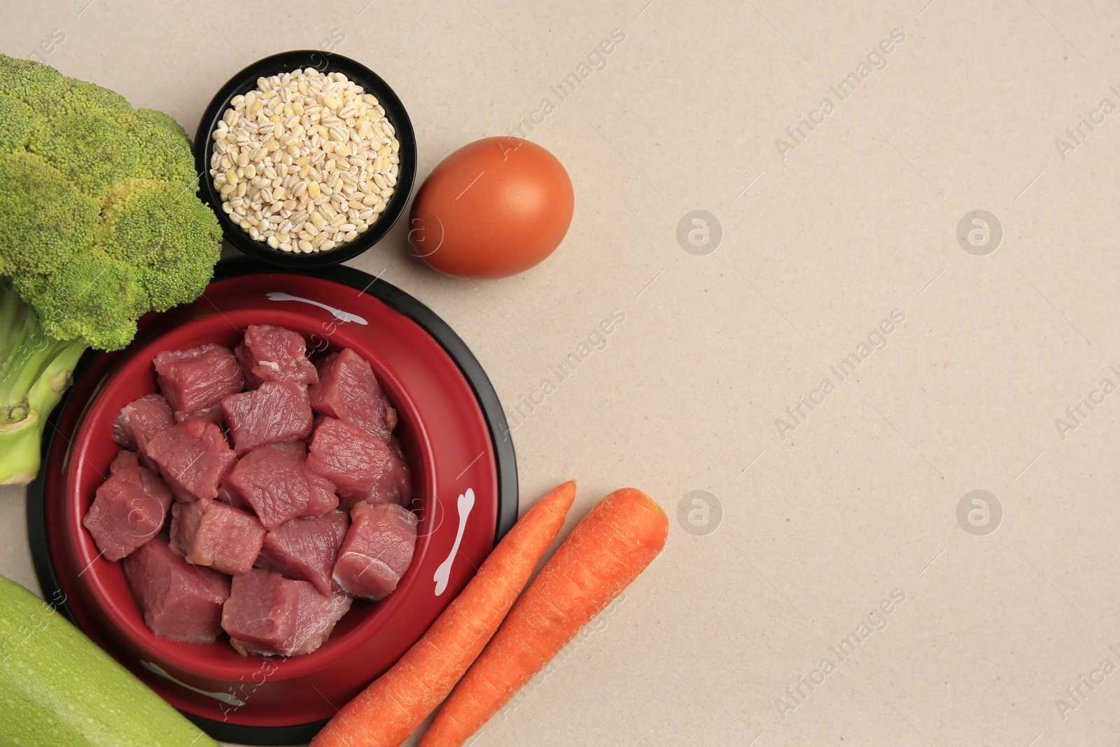 Photo of Raw meat in bowl and healthy products for pet on beige background, flat lay. Space for text