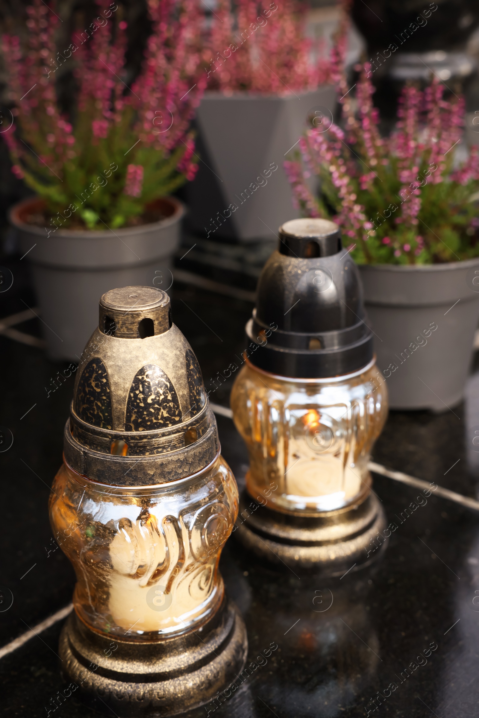 Photo of Grave lanterns on black tiled surface at cemetery