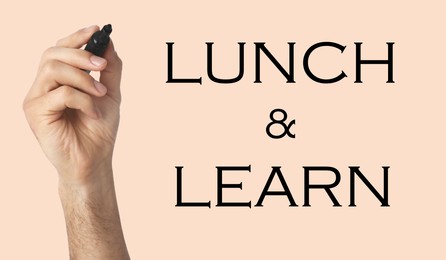 Image of Lunch and Learn concept. Man with marker on beige background, closeup